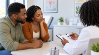 Black couple consulting a doctor whose face is not shown